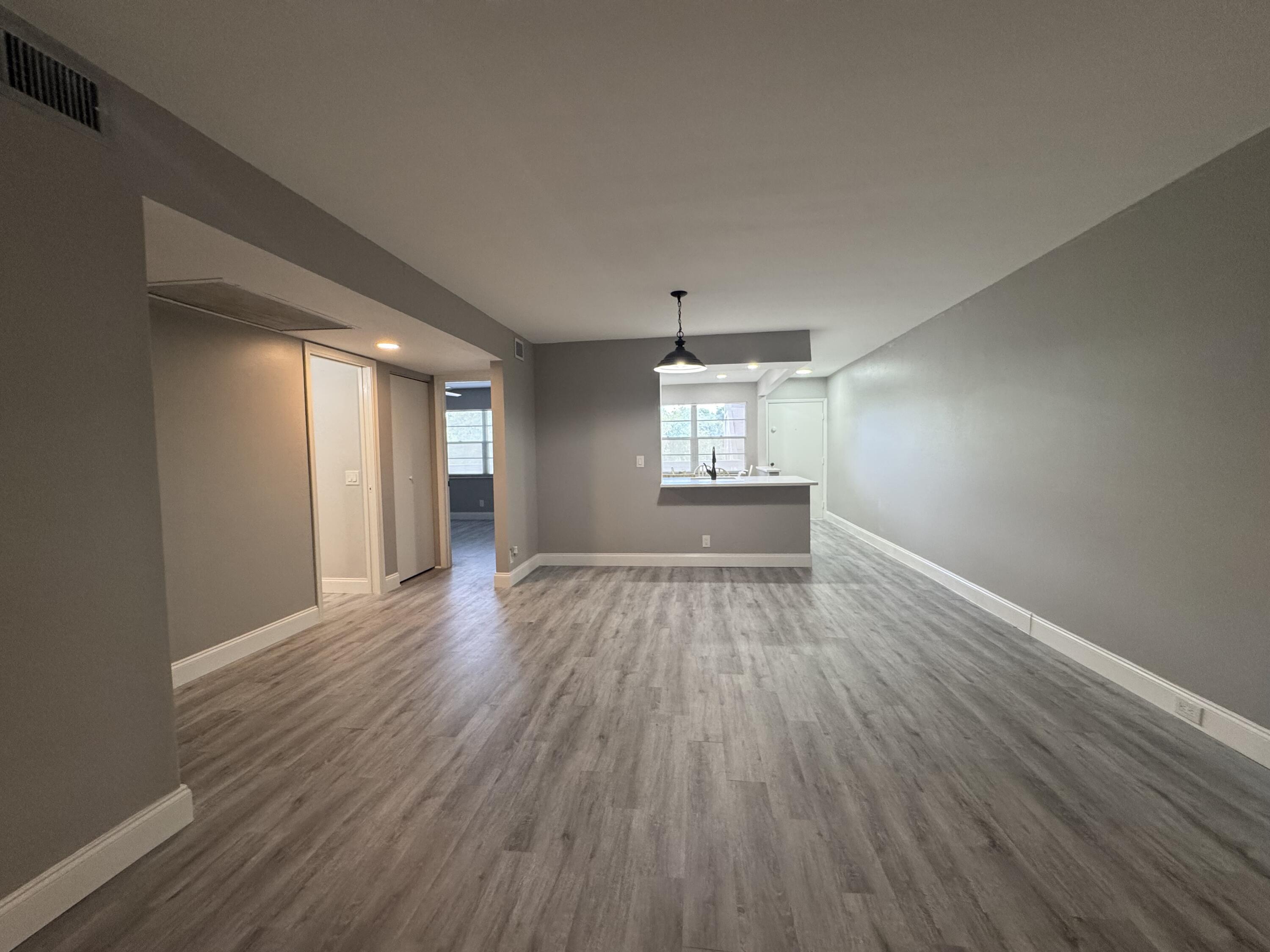 4401 Martinique Court, Unit G2 Coconut Creek, FL 33066 - Photo 4 of 22 wooden floor in an empty room with a window