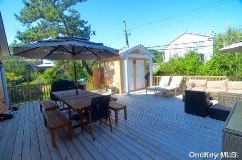 368 Surf Road Ocean Beach, NY 11770 - Photo 9 of 11 a view of a patio with table and chairs under an umbrella with wooden floor