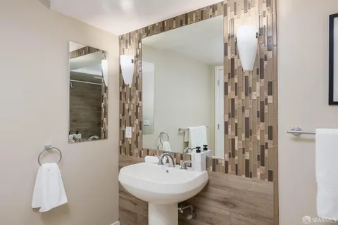 a bathroom with a double vanity sink toilet mirror and shower