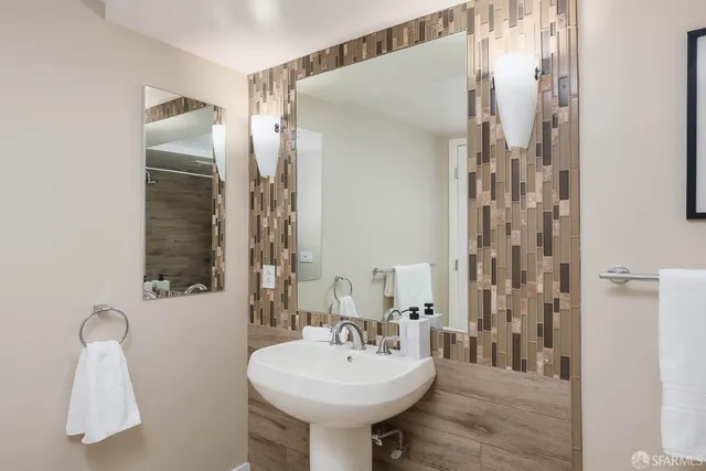 a bathroom with a double vanity sink toilet mirror and shower