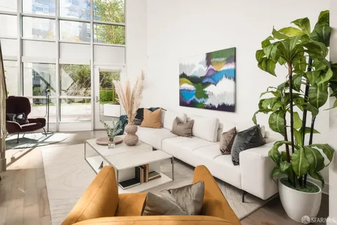 a living room with furniture plant and a large window