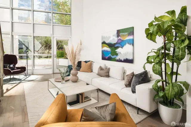 a living room with furniture plant and a large window