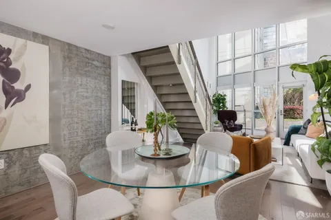 a dining room with furniture a potted plant and wooden floor