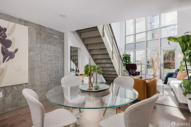 a dining room with furniture a potted plant and wooden floor