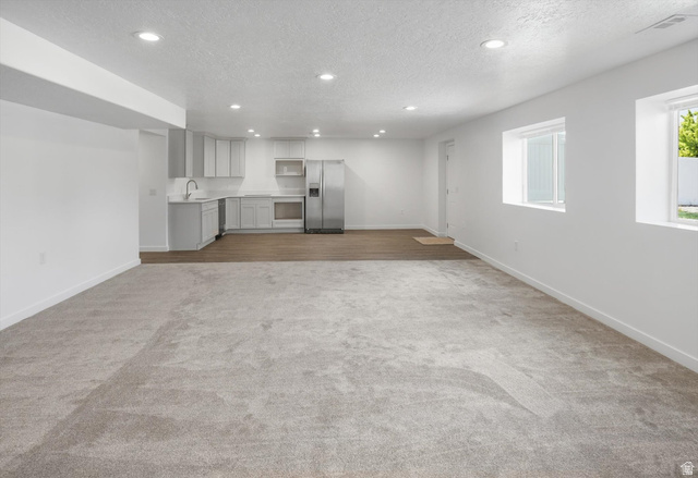 3636 West 910 South Syracuse, UT 84075 - Photo 51 of 70 Open-concept living space featuring a full kitchen with light gray cabinetry, stainless steel appliances, and a stainless steel sink with a gooseneck faucet