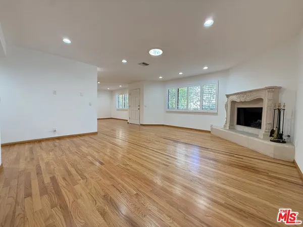 an empty room with wooden floor and fireplace