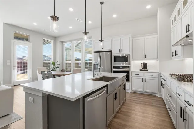 a kitchen with stainless steel appliances granite countertop a sink stove and refrigerator