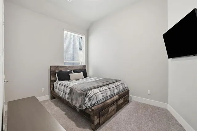 a bedroom with a bed and a flat screen tv