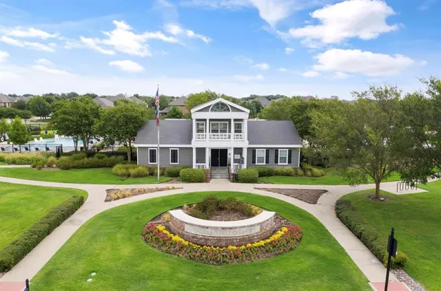 a front view of a house with a garden and trees