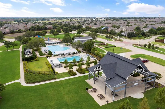 an aerial view of residential houses with outdoor space and parking