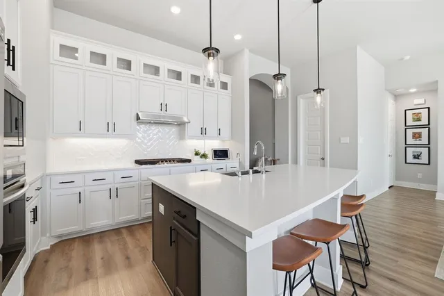 a kitchen with a white center island and chairs