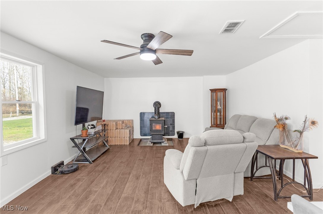 6590 Hall Road Andover, OH 44003 - Photo 13 of 29 Living area featuring a wood stove, wood finished floors, and ceiling fan