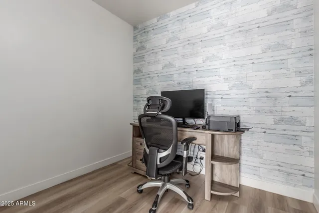 a view of a workspace with furniture and wooden floor
