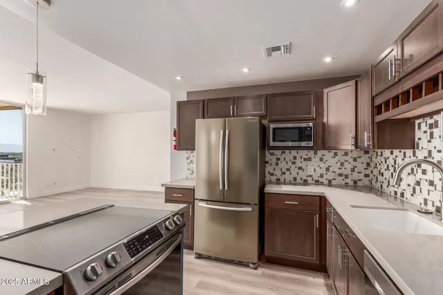 a kitchen with stainless steel appliances granite countertop a refrigerator and a sink