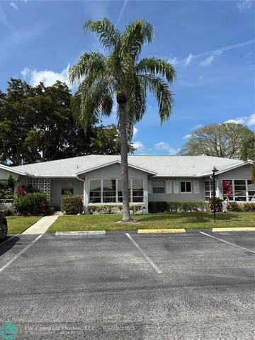a front view of a house with a yard and potted plants