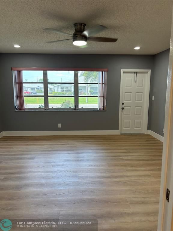14748 Canalview Drive, Unit B Delray Beach, FL 33484 - Photo 9 of 12 an empty room with wooden floor and windows