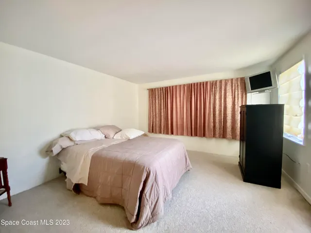 a bedroom with a bed and a television