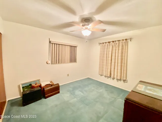 an empty room with windows and ceiling fan