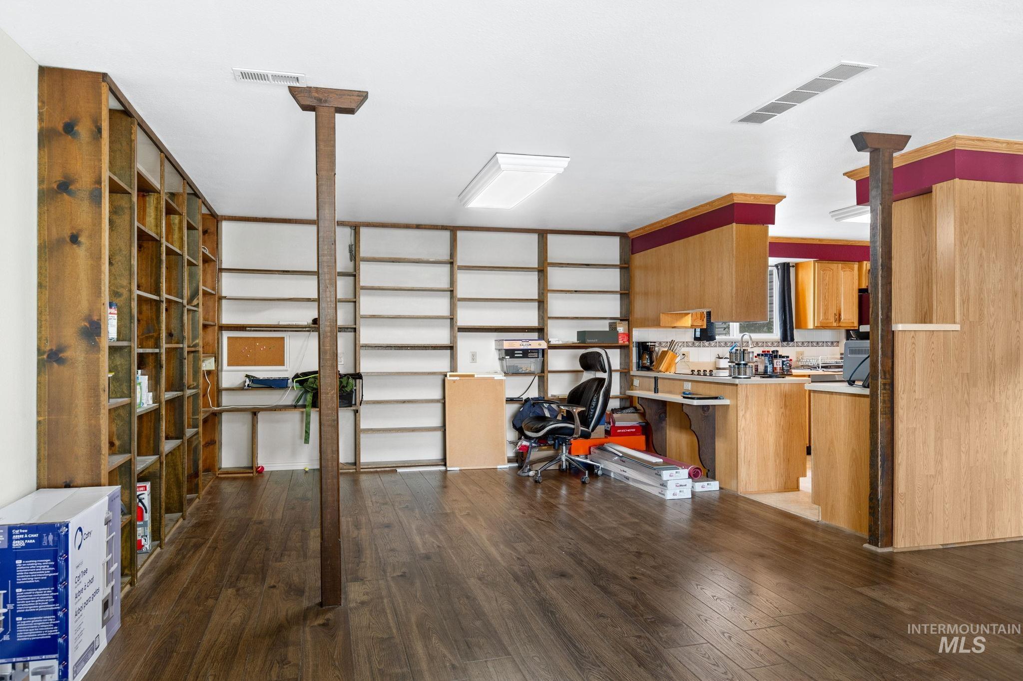 18338 Pride Lane Caldwell, ID 83607 - Photo 16 of 50 Spacious interior featuring wood-finish flooring, extensive built-in shelving, natural wood support beams, and recessed lighting