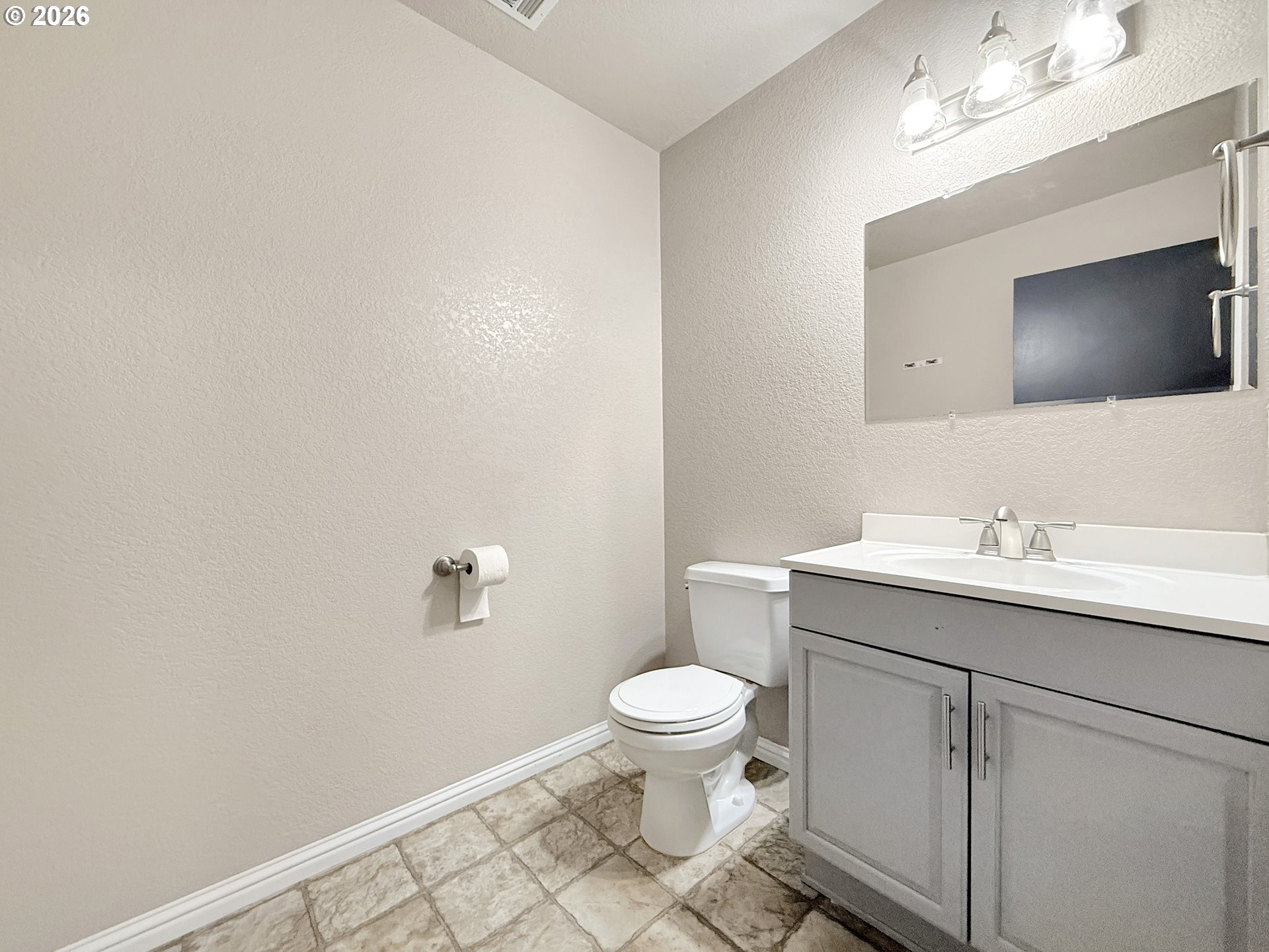 325 Matot Street, Unit B Brookings, OR 97415 - Photo 17 of 28 a bathroom with a sink a toilet a mirror and vanity