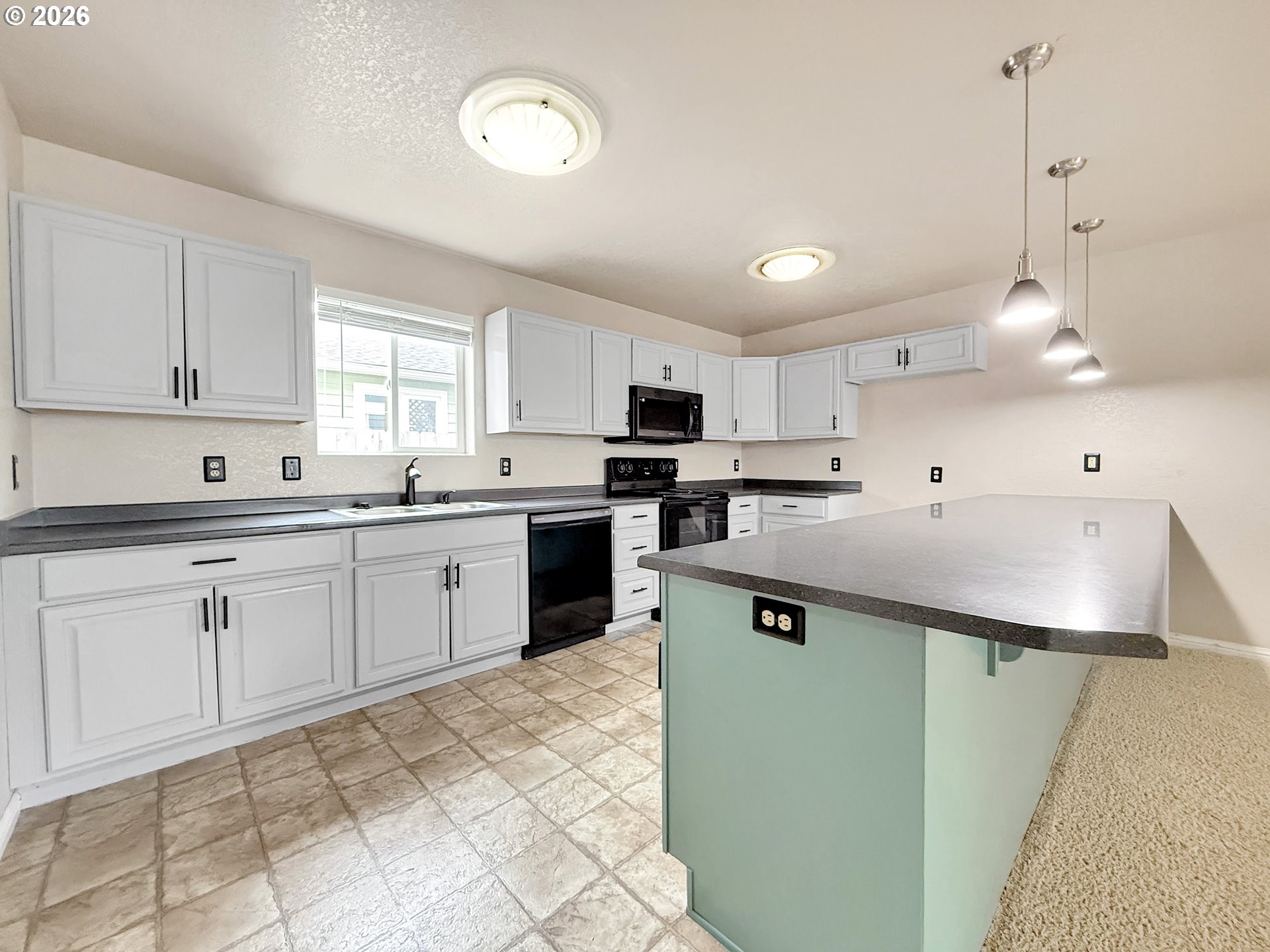 325 Matot Street, Unit B Brookings, OR 97415 - Photo 7 of 28 a kitchen with a sink window and cabinets