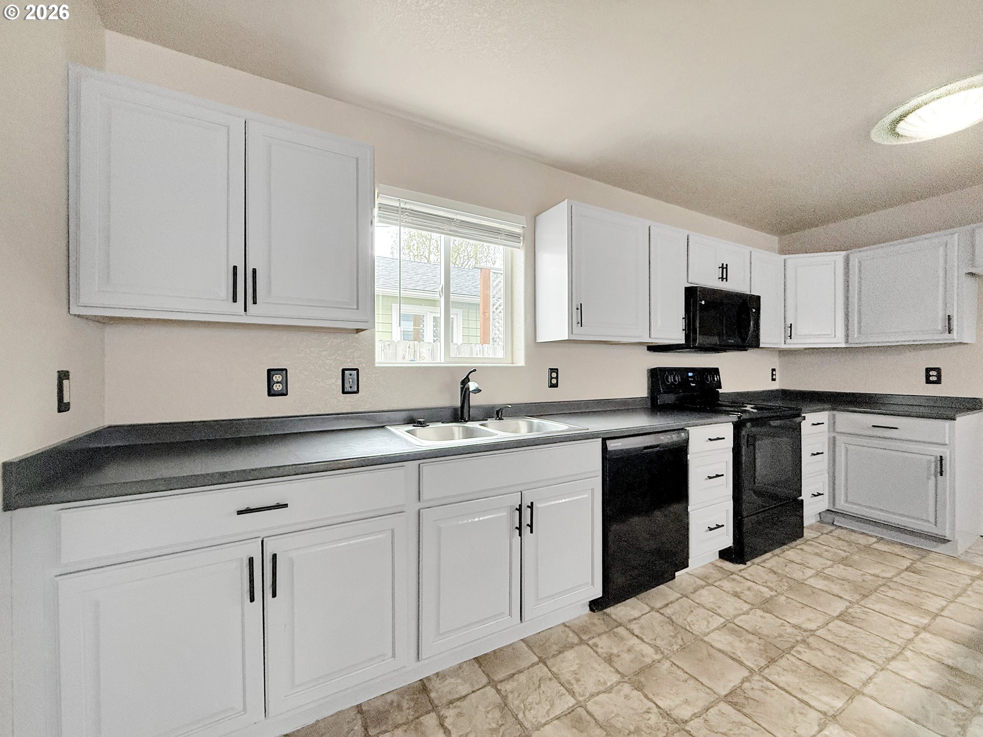 325 Matot Street, Unit B Brookings, OR 97415 - Photo 9 of 28 a kitchen with granite countertop white cabinets sink and stainless steel appliances