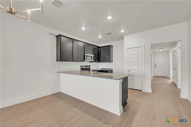 an empty room with a kitchen and a sink