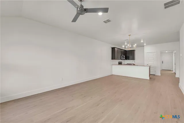 a view of a big room with wooden floor and windows