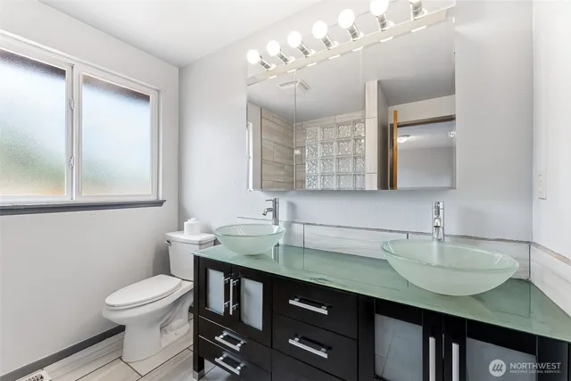 a bathroom with a granite countertop sink a toilet and a mirror