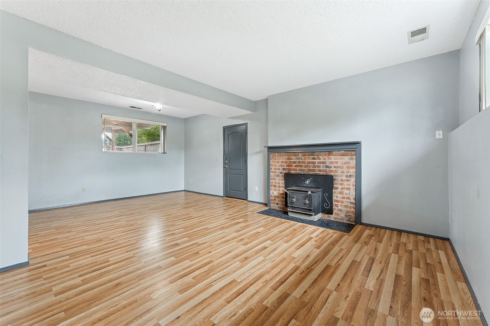 10014 108th Avenue Southwest Tacoma, WA 98498 - Photo 19 of 39 a view of empty room with wooden floor and fireplace