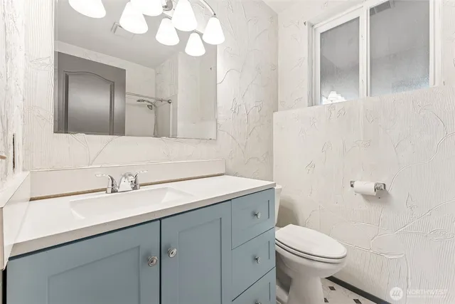 a bathroom with a sink a toilet and a mirror