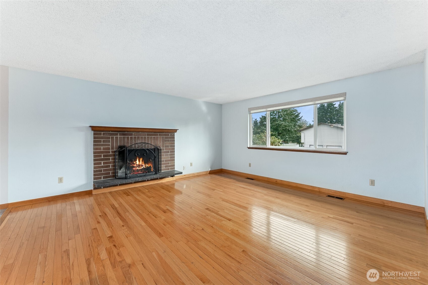 10014 108th Avenue Southwest Tacoma, WA 98498 - Photo 6 of 39 a view of empty room with wooden floor and fireplace
