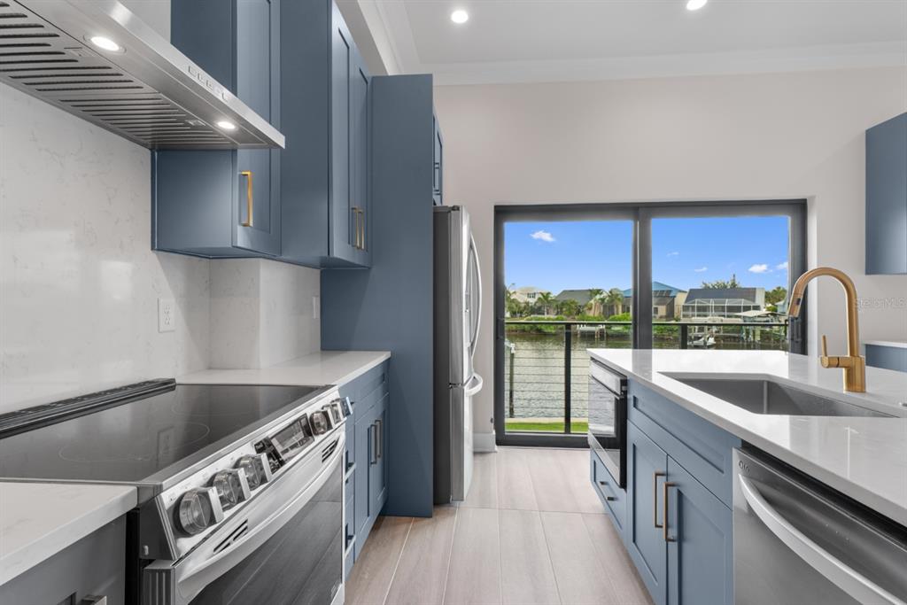 775 Gran Kaymen Way Apollo Beach, FL 33572 - Photo 11 of 43 a kitchen with stainless steel appliances granite countertop a sink a stove and a refrigerator