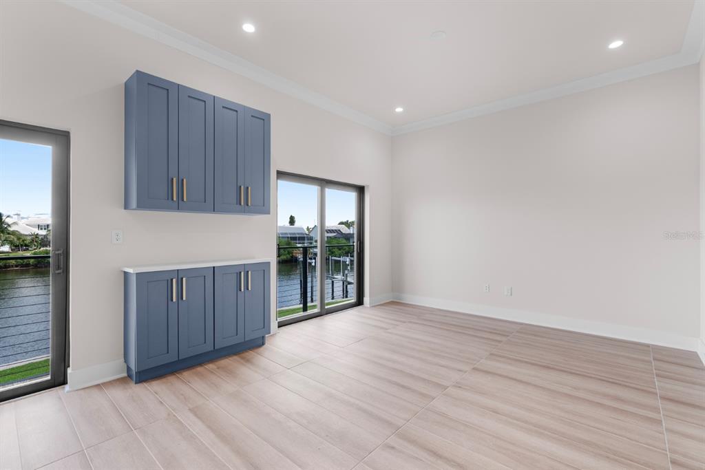 775 Gran Kaymen Way Apollo Beach, FL 33572 - Photo 10 of 43 a view of an empty room with wooden floor and a cabinet