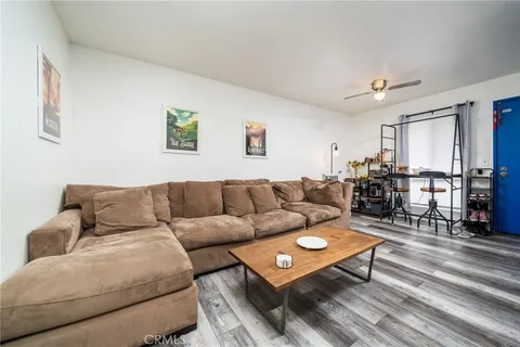 a living room with furniture a wooden floor and a ceiling fan