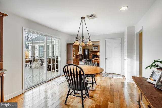 a dining room with furniture a chandelier and wooden floor