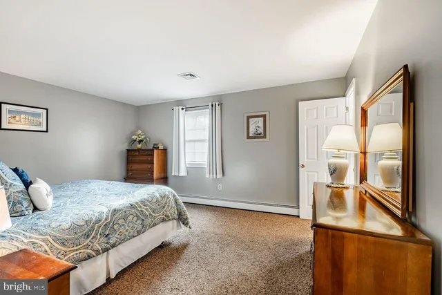 a bedroom with a large bed and wooden floor