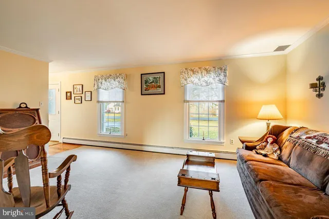 a living room with furniture a couch and dresser with wooden floor