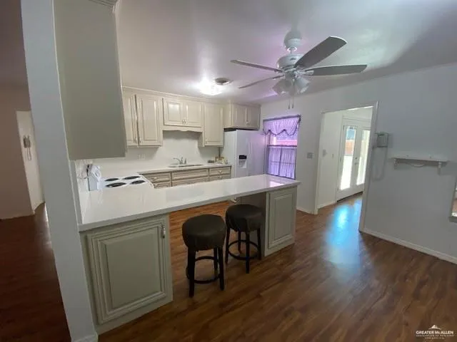 a kitchen with a sink cabinets and wooden floor