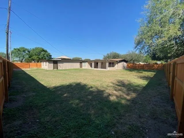 a view of back yard of the house with a yard