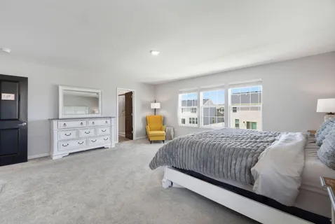 a bedroom with a bed a couch and dresser