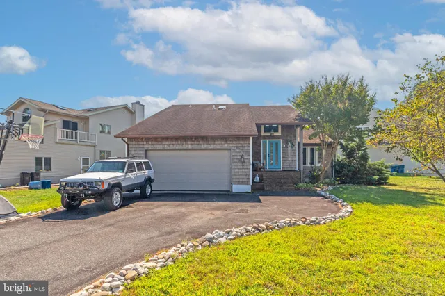 a front view of a house with a garden and parking