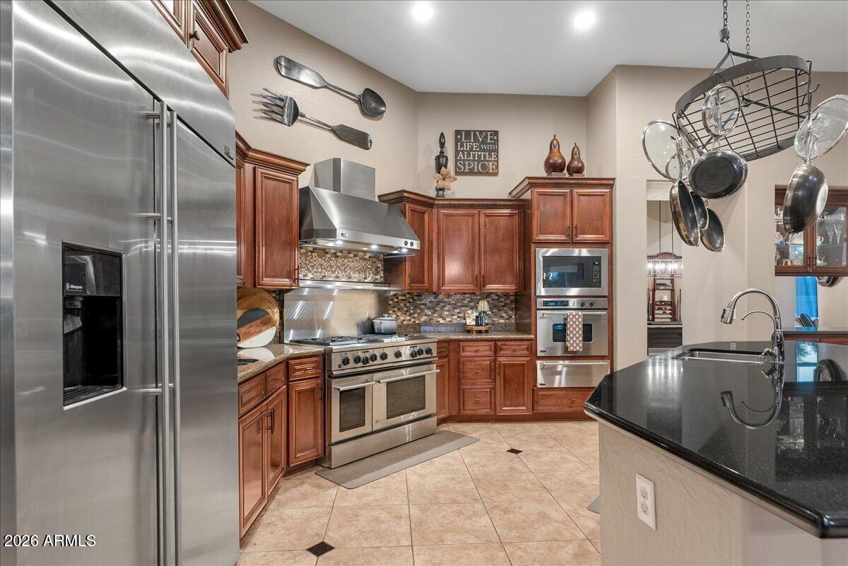 6427 South Magic Court Gilbert, AZ 85298 - Photo 10 of 71 a kitchen with stainless steel appliances granite countertop a sink stove and refrigerator