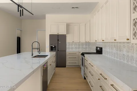 a kitchen with stainless steel appliances granite countertop a refrigerator and a stove