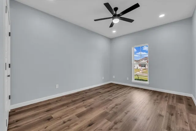 an empty room with closet and a ceiling fan