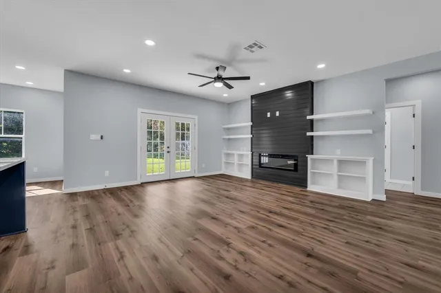 a view of a room with wooden floors and ceiling fan