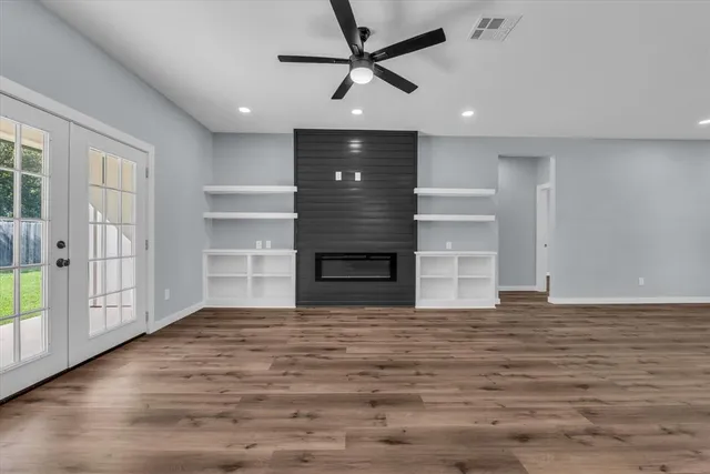 a view of an empty room with a fireplace and a window