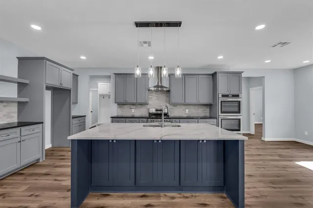 a large kitchen with kitchen island a sink stainless steel appliances and cabinets