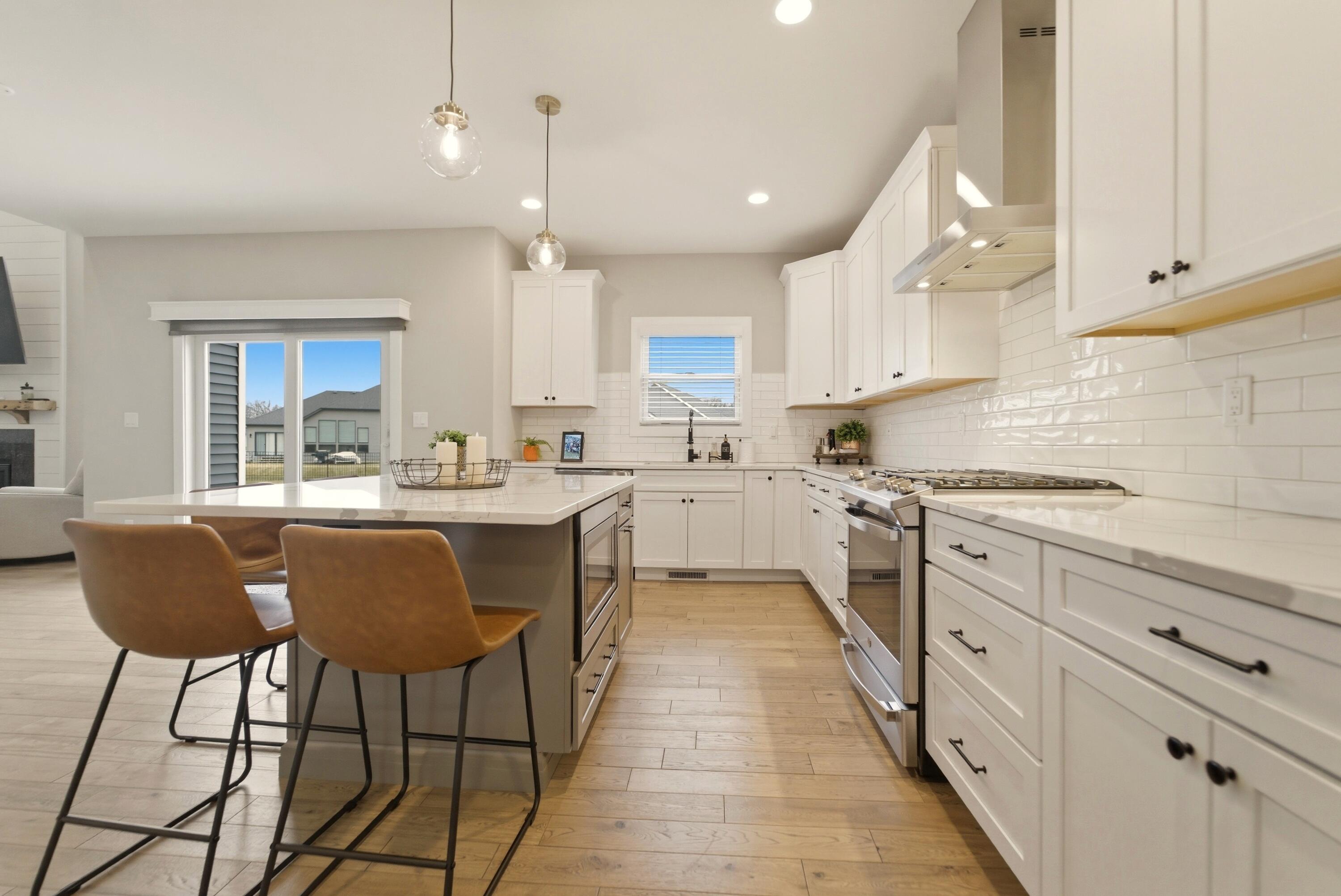 11200 Oak Ridge Court Crown Point, IN 46307 - Photo 11 of 43 a kitchen with stainless steel appliances granite countertop a sink a stove a refrigerator and island with wooden floor