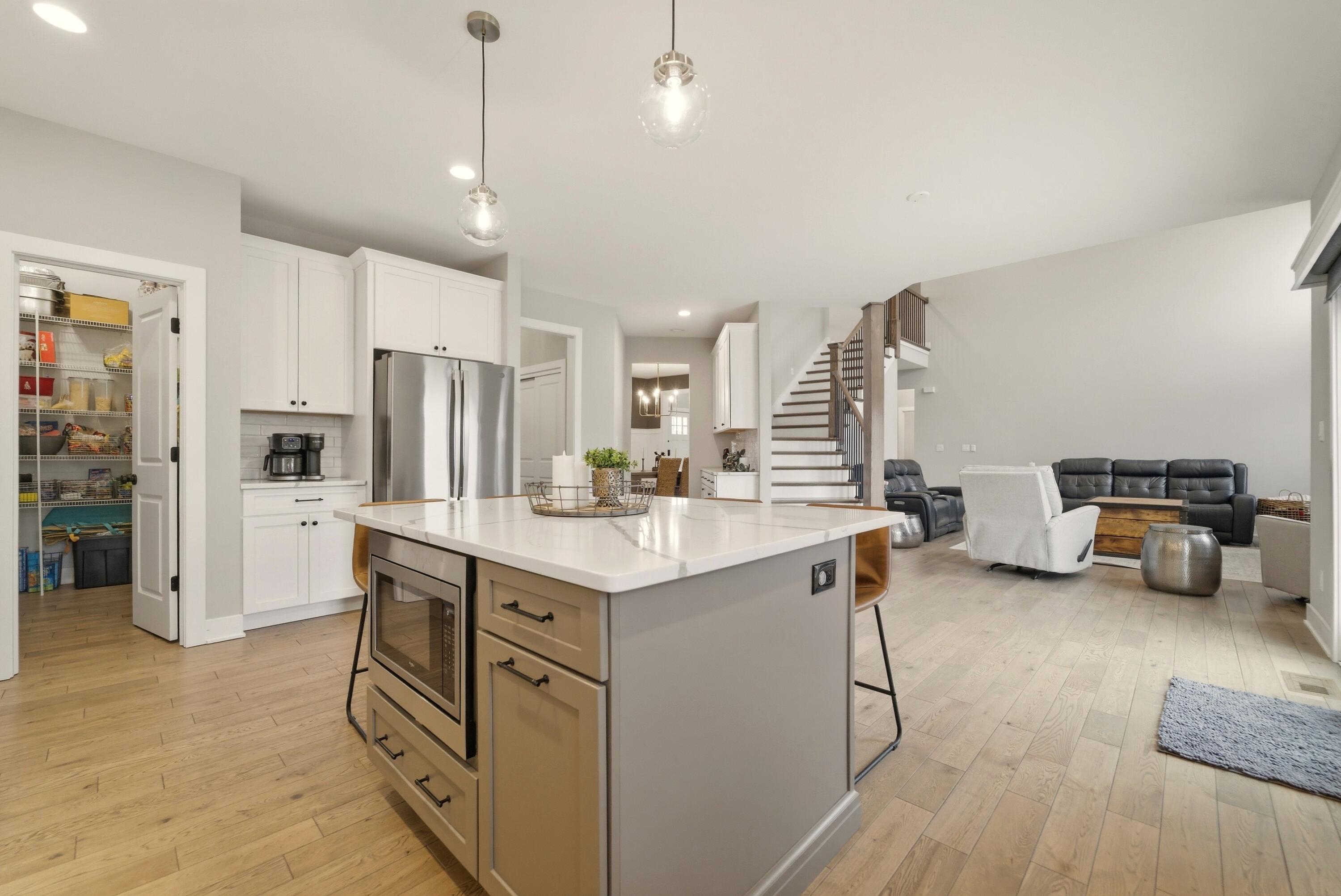 11200 Oak Ridge Court Crown Point, IN 46307 - Photo 12 of 43 a kitchen with stainless steel appliances a refrigerator a sink dishwasher stove and white cabinets next to a window